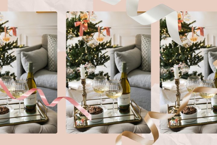 Bottle of La Crema wine and two glasses on a tray in front of a holiday tree